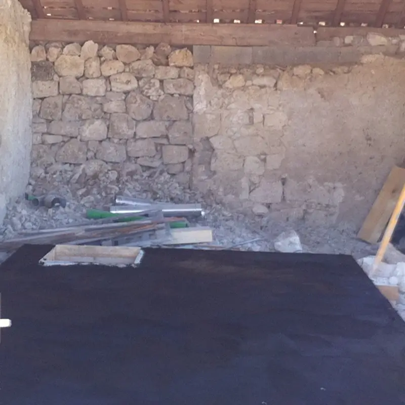 Toiture de bunker privé formant le nouveau niveau de sol dans une bâtisse en pierre avant aménagement.