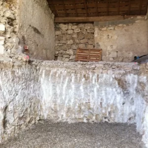 Creusement du volume sous une grange en pierre pour la construction d’un bunker privé enterré.