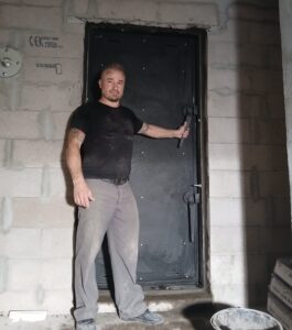 Pose d'une porte de bunker lors de la transformation d'une garage en abri sécurisé NRBC.
