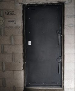 Porte de bunker installée dans un ouvrage en béton.